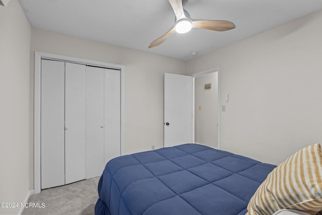 bedroom featuring a closet, light colored carpet, and ceiling fan