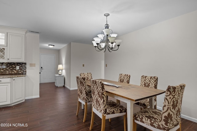 dining space with dark wood-type flooring and a chandelier