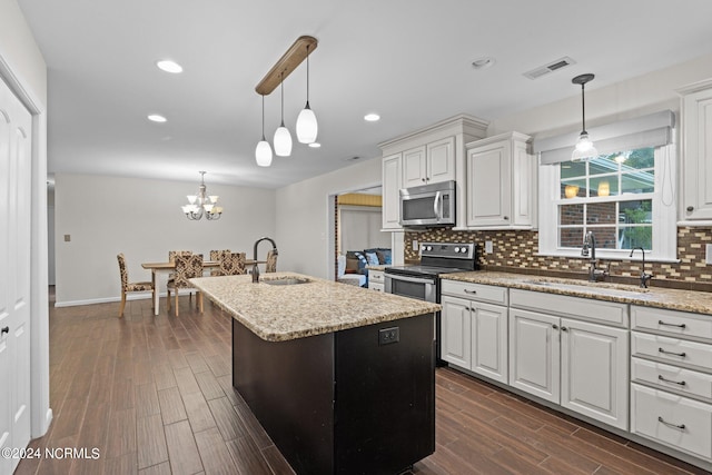 kitchen featuring sink, an island with sink, stainless steel appliances, and white cabinets