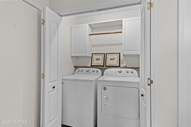 clothes washing area featuring independent washer and dryer and cabinets