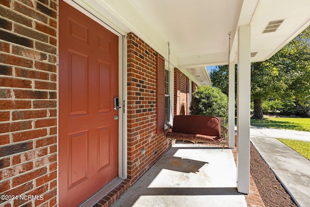 view of exterior entry featuring covered porch