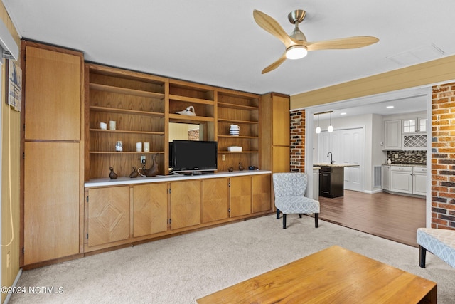 living room with light hardwood / wood-style floors, sink, and ceiling fan