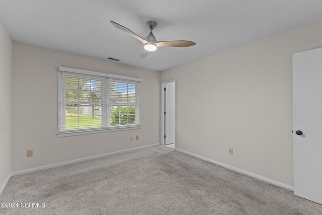 carpeted empty room featuring a textured ceiling and ceiling fan