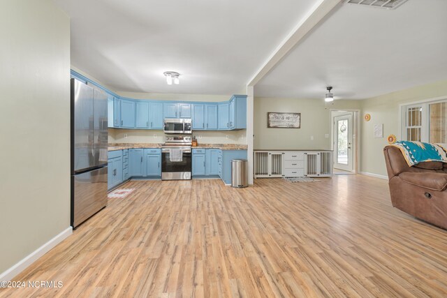 kitchen featuring appliances with stainless steel finishes, sink, light hardwood / wood-style flooring, and blue cabinetry