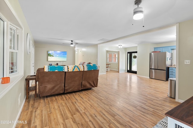 living room featuring ceiling fan and light hardwood / wood-style flooring