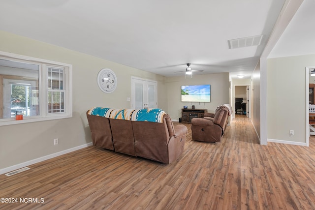 living room with ceiling fan and light hardwood / wood-style flooring