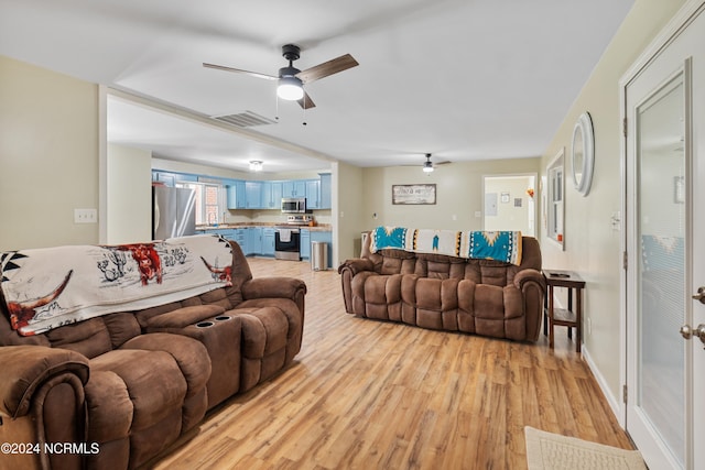 living room featuring ceiling fan and light hardwood / wood-style floors