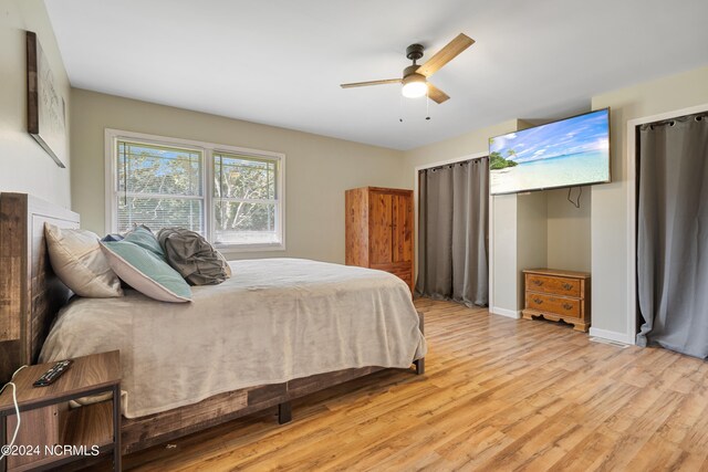 clothes washing area with cabinets, washer / clothes dryer, and light hardwood / wood-style flooring