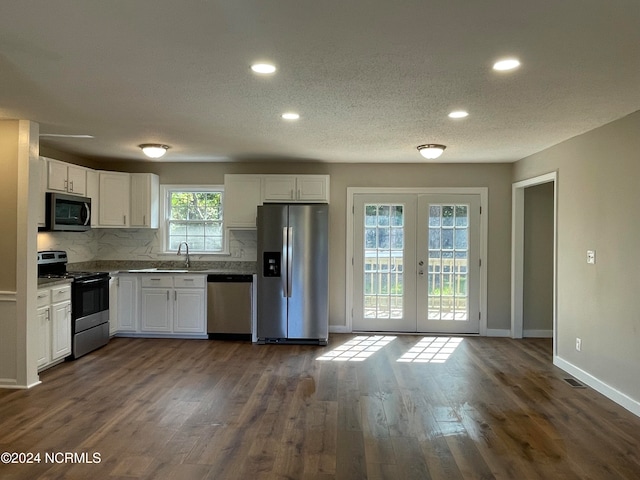 kitchen featuring appliances with stainless steel finishes, dark hardwood / wood-style flooring, white cabinetry, and a healthy amount of sunlight