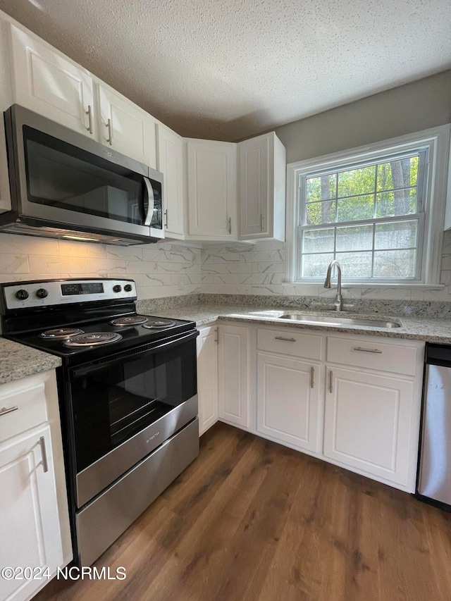 kitchen featuring white cabinets, sink, tasteful backsplash, stainless steel appliances, and dark hardwood / wood-style flooring