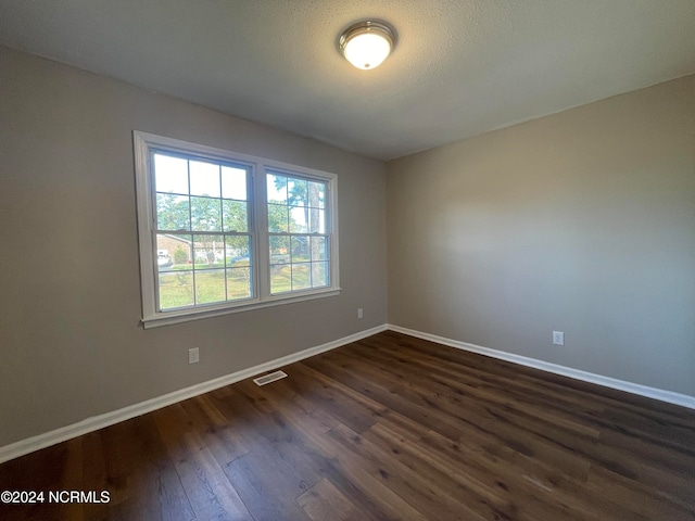 empty room with dark wood-type flooring