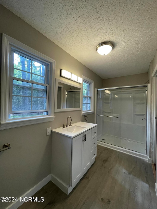 bathroom featuring an enclosed shower, hardwood / wood-style flooring, a healthy amount of sunlight, and vanity