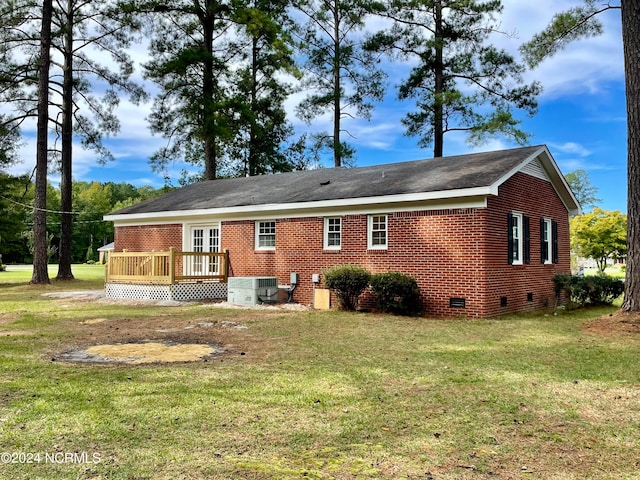 back of property featuring a wooden deck, a yard, and central AC