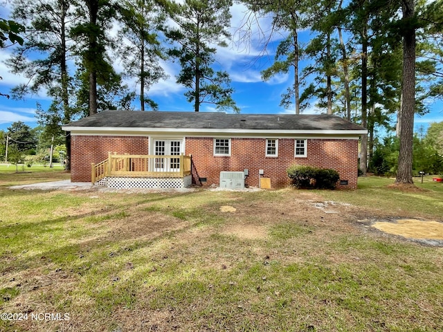 back of property with french doors and a lawn