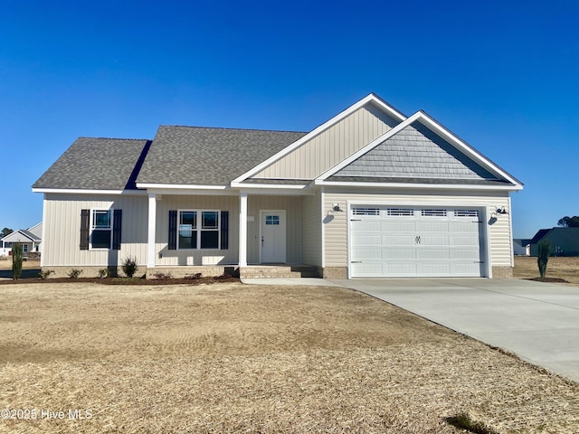 view of front of house with a garage, concrete driveway, and a shingled roof