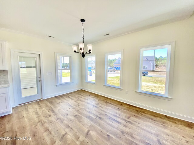 unfurnished living room featuring wood-type flooring, lofted ceiling, a large fireplace, and a chandelier