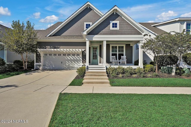 view of front facade featuring a garage, a porch, and a front lawn