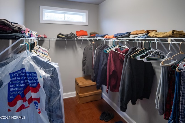 walk in closet with dark hardwood / wood-style floors