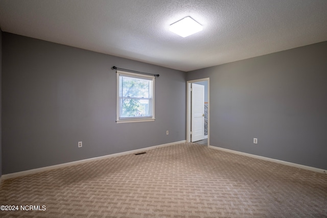 carpeted spare room featuring a textured ceiling and ceiling fan