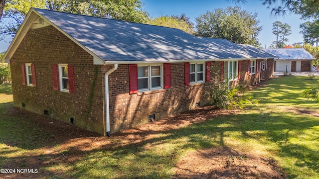 view of property exterior with french doors and a lawn