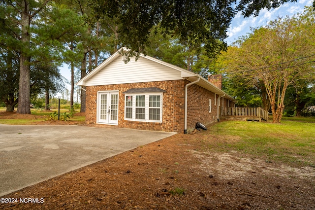 view of home's exterior featuring a deck and a yard