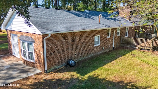 rear view of house featuring a yard and a wooden deck