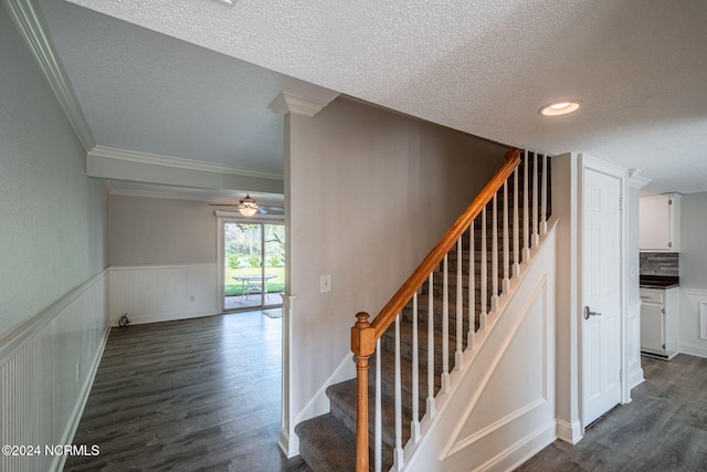 stairs with ceiling fan, crown molding, decorative columns, hardwood / wood-style flooring, and a textured ceiling