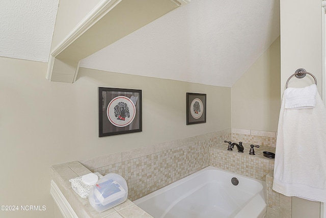 bathroom featuring a textured ceiling, lofted ceiling, and a bath