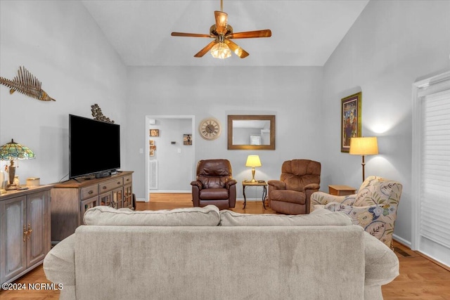 living room featuring ceiling fan, high vaulted ceiling, and light wood-type flooring