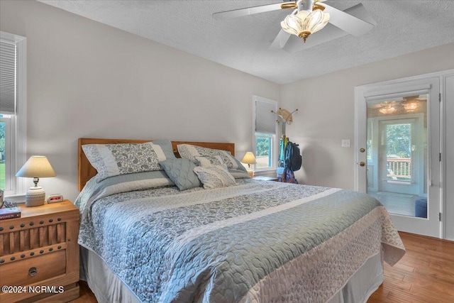 bedroom featuring multiple windows, a textured ceiling, and ceiling fan