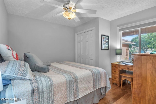 bedroom featuring light hardwood / wood-style flooring, a textured ceiling, a closet, and ceiling fan