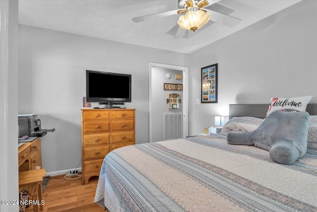 bedroom featuring ceiling fan, a textured ceiling, and hardwood / wood-style floors