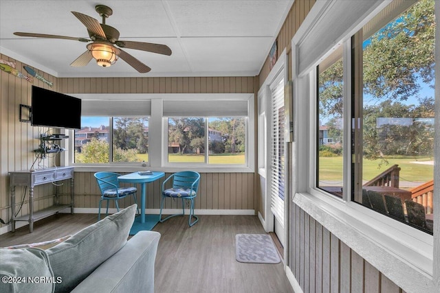 sunroom / solarium featuring plenty of natural light and ceiling fan