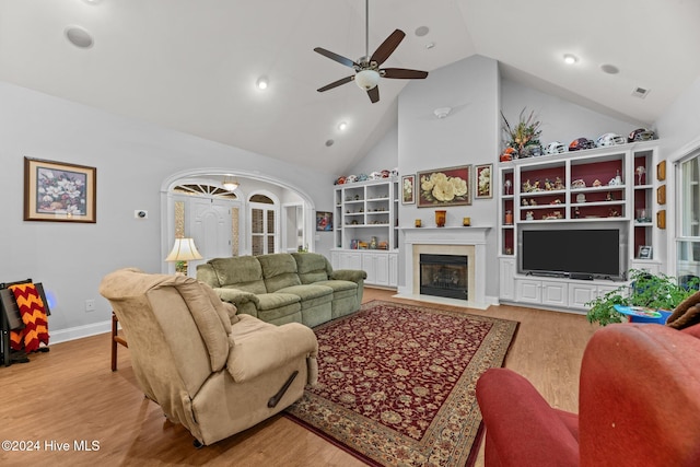 living room featuring ceiling fan, high vaulted ceiling, and light hardwood / wood-style flooring