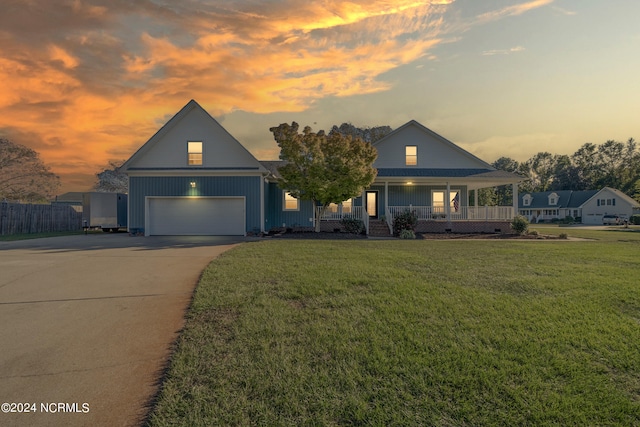 view of front of home with a garage, a porch, and a lawn