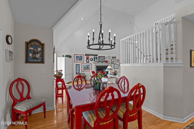 dining room with light hardwood / wood-style flooring, a chandelier, and lofted ceiling