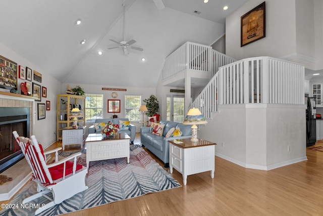 living room featuring light wood-type flooring, high vaulted ceiling, and ceiling fan