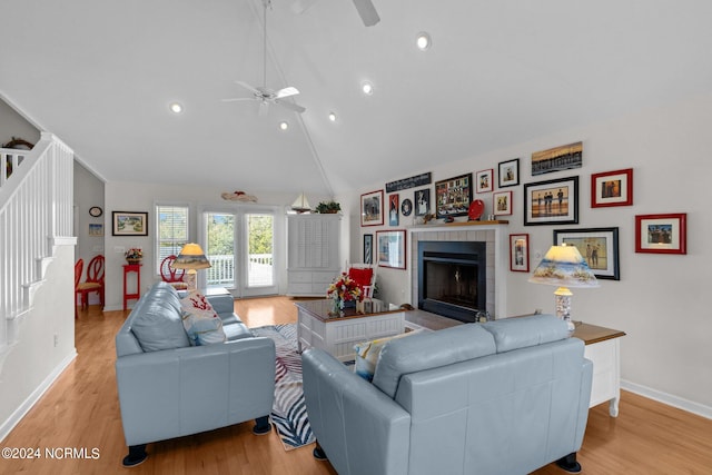 living room with lofted ceiling, light wood-type flooring, and ceiling fan