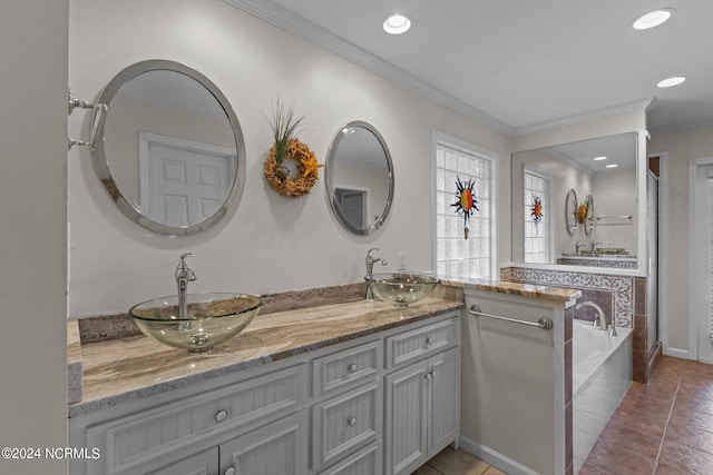 bathroom featuring tile patterned flooring, crown molding, a relaxing tiled tub, and vanity