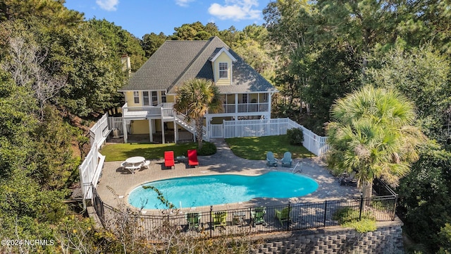 exterior space with a fenced in pool, a lawn, a patio area, and a sunroom