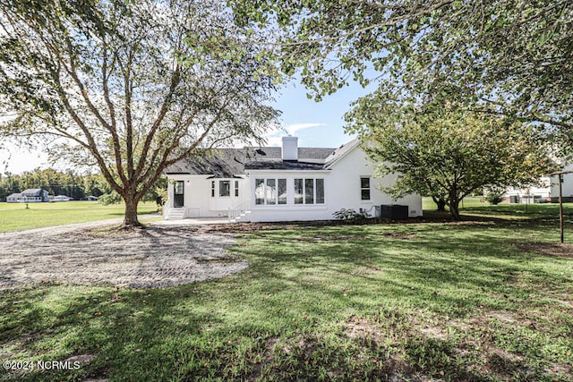 rear view of house featuring a lawn