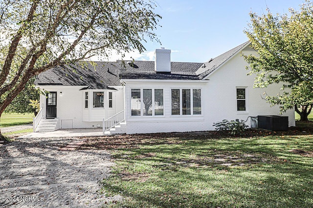 back of property with a lawn and central AC unit