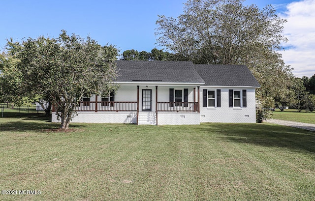 ranch-style house featuring covered porch and a front yard