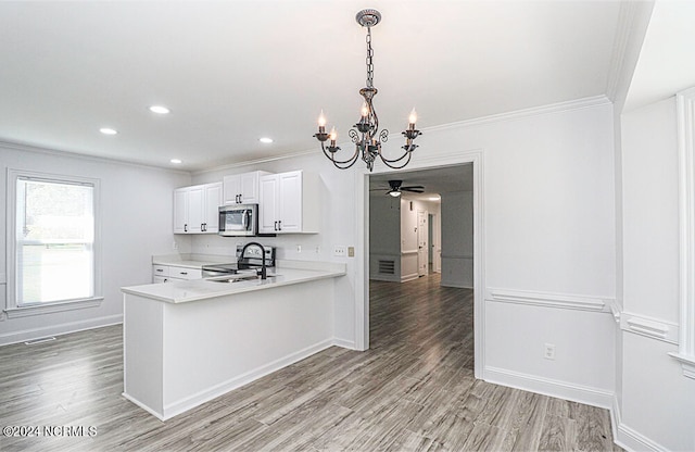 kitchen with kitchen peninsula, light hardwood / wood-style floors, white cabinets, and sink