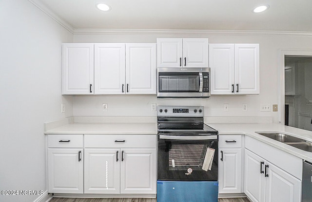 kitchen with appliances with stainless steel finishes, white cabinetry, and ornamental molding