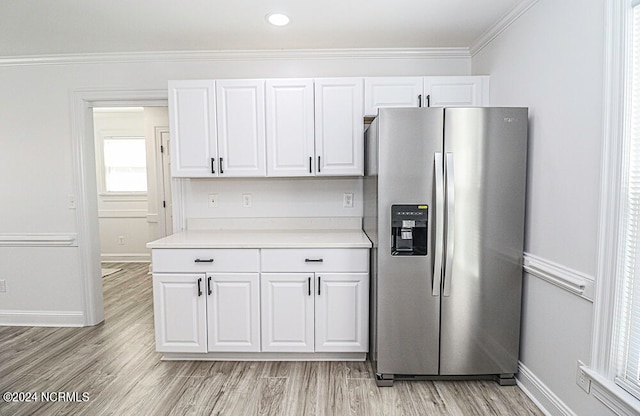 kitchen with stainless steel fridge, light hardwood / wood-style floors, crown molding, and white cabinetry