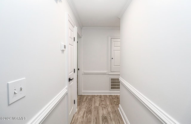 corridor featuring light hardwood / wood-style flooring and ornamental molding