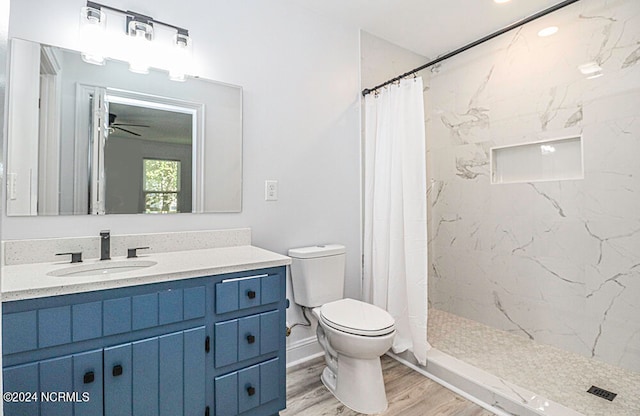 bathroom featuring hardwood / wood-style floors, ceiling fan, toilet, and a shower with curtain