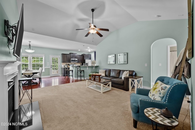 living room featuring hardwood / wood-style floors, ceiling fan, and vaulted ceiling