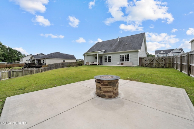 back of house featuring a yard, a patio, and a fire pit